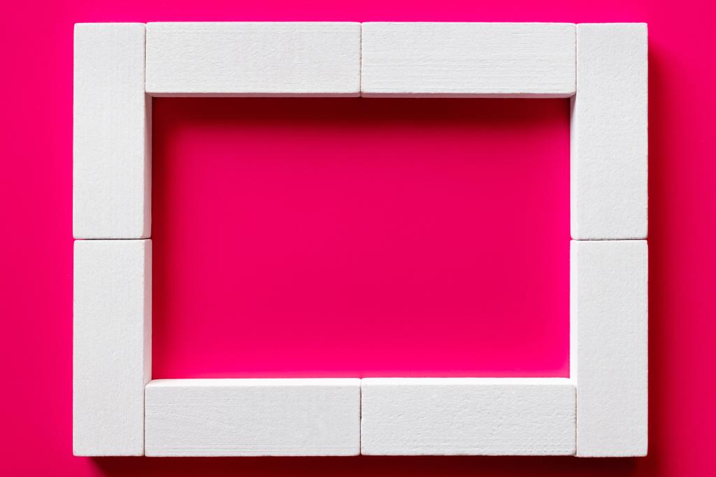 top view of white blocks frame on pink background - Photo, Image