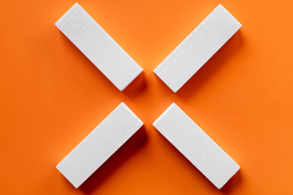 Parlak turuncu arkaplandaki beyaz tetragonal blokların üst görünümü - Fotoğraf, Görsel