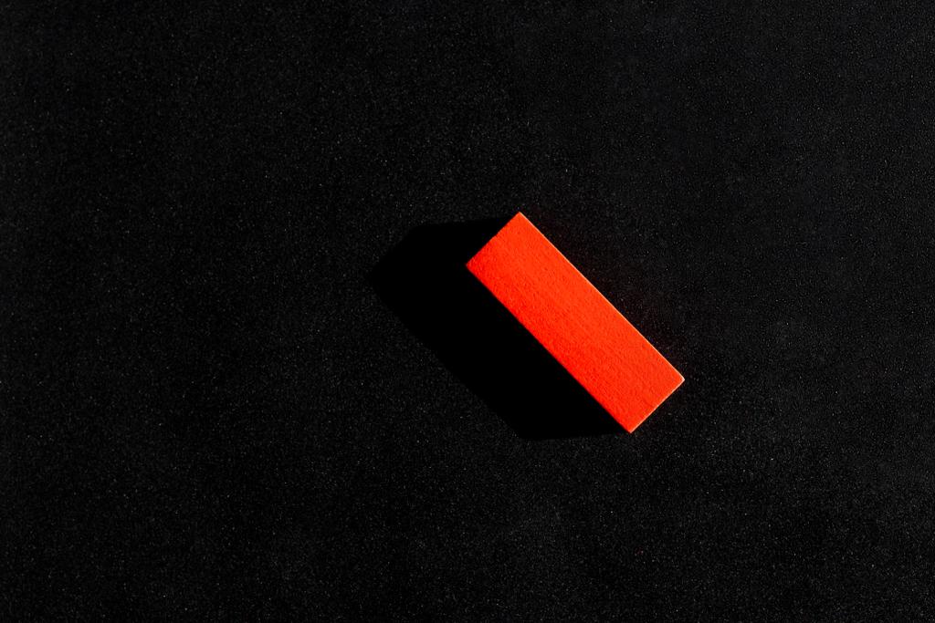 Draufsicht auf roten rechteckigen Block auf schwarzem Hintergrund mit Kopierraum - Foto, Bild
