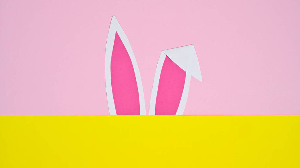 Orecchie di coniglio su sfondo rosa pastello e giallo. FLat lay concetto creativo minimo - Foto, immagini