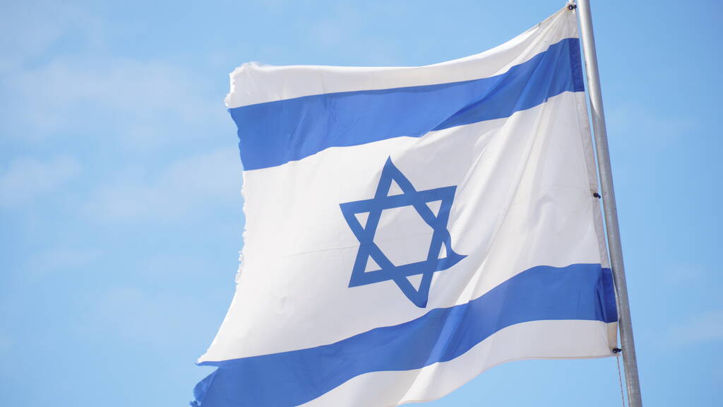 イスラエルの国旗が明るい空に向かって風になびく - 写真・画像