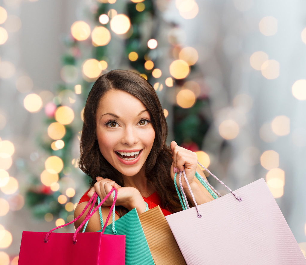 mulher sorridente com sacos de compras coloridos
 - Foto, Imagem