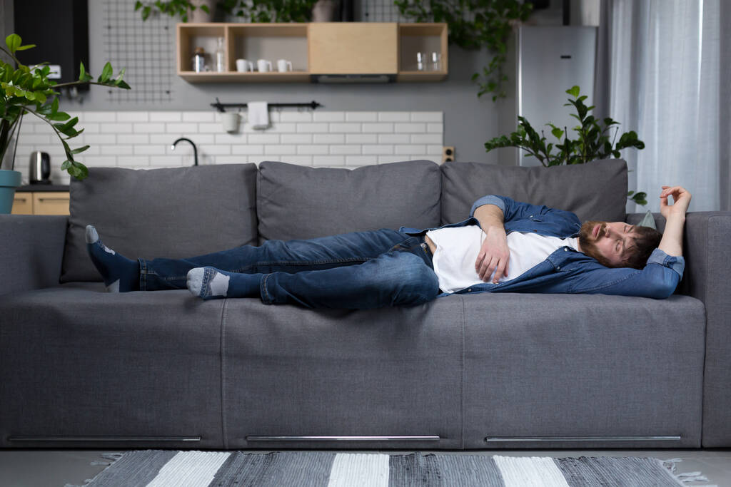 Чоловік вдома втомився після роботи спить на дивані
 - Фото, зображення