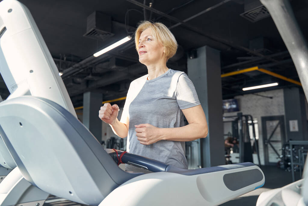 Femme sportive active faisant de l'exercice cardio dans la salle de gym - Photo, image