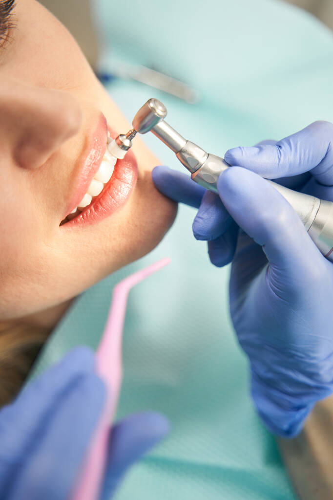 Женщина проходит стоматологическую процедуру в стоматологической клинике - Фото, изображение