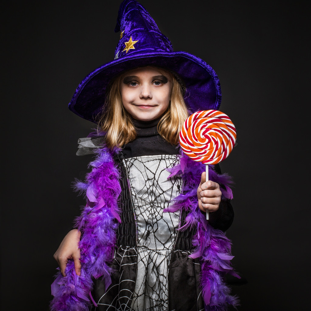 Pequeña hermosa bruja de Halloween con dulces de colores
 - Foto, Imagen