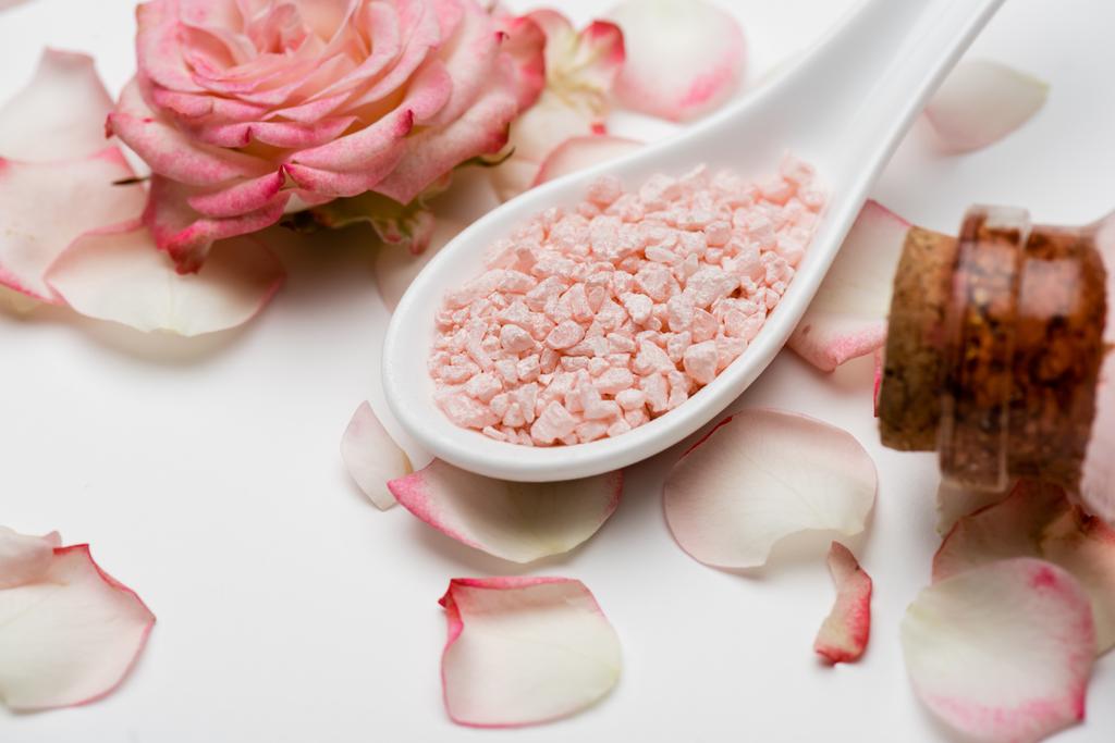 крупним планом вид на квітку біля пелюсток і рожеву морську сіль на білому
 - Фото, зображення