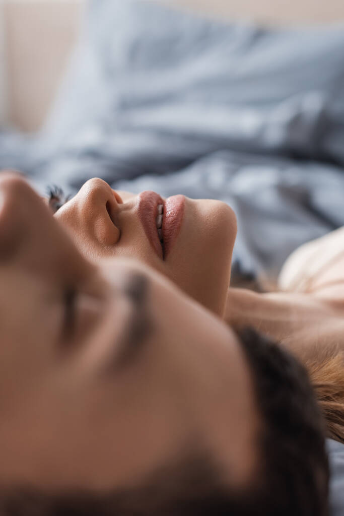 Jovem deitada perto de namorado borrado na cama em casa  - Foto, Imagem