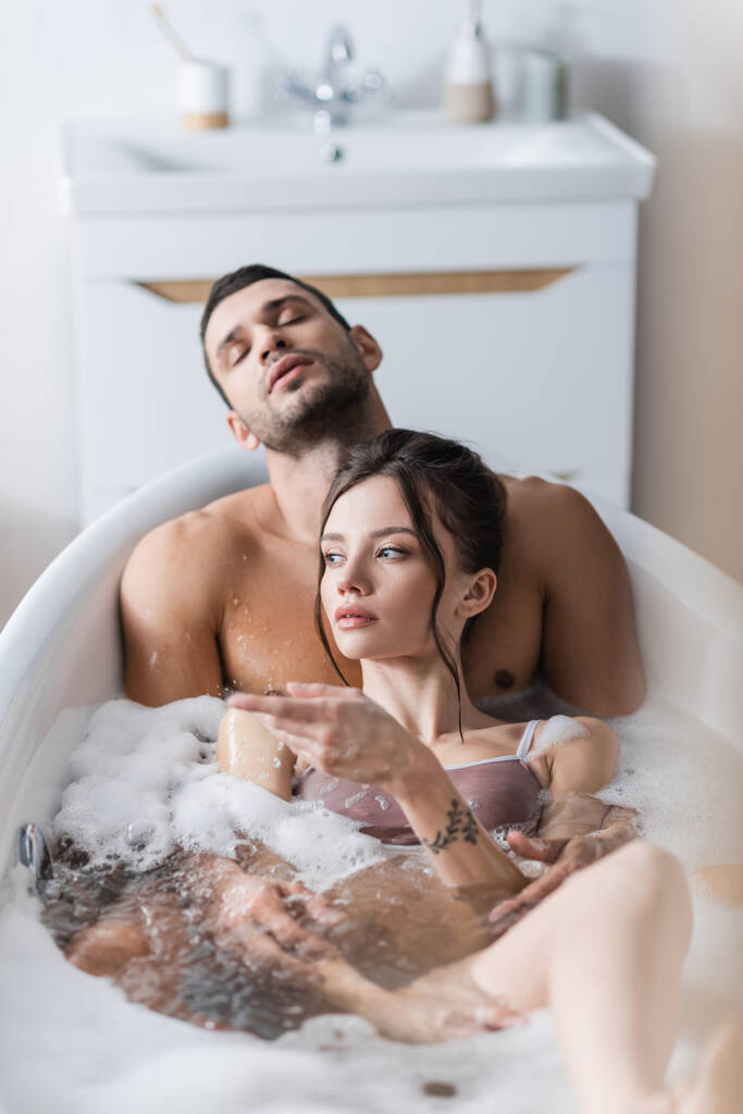Kadın evde seksi erkek arkadaşıyla banyo yaparken parmağıyla işaret ediyor.  - Fotoğraf, Görsel