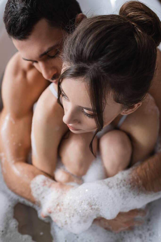 Vue aérienne de l'homme musclé embrassant petite amie dans le bain - Photo, image
