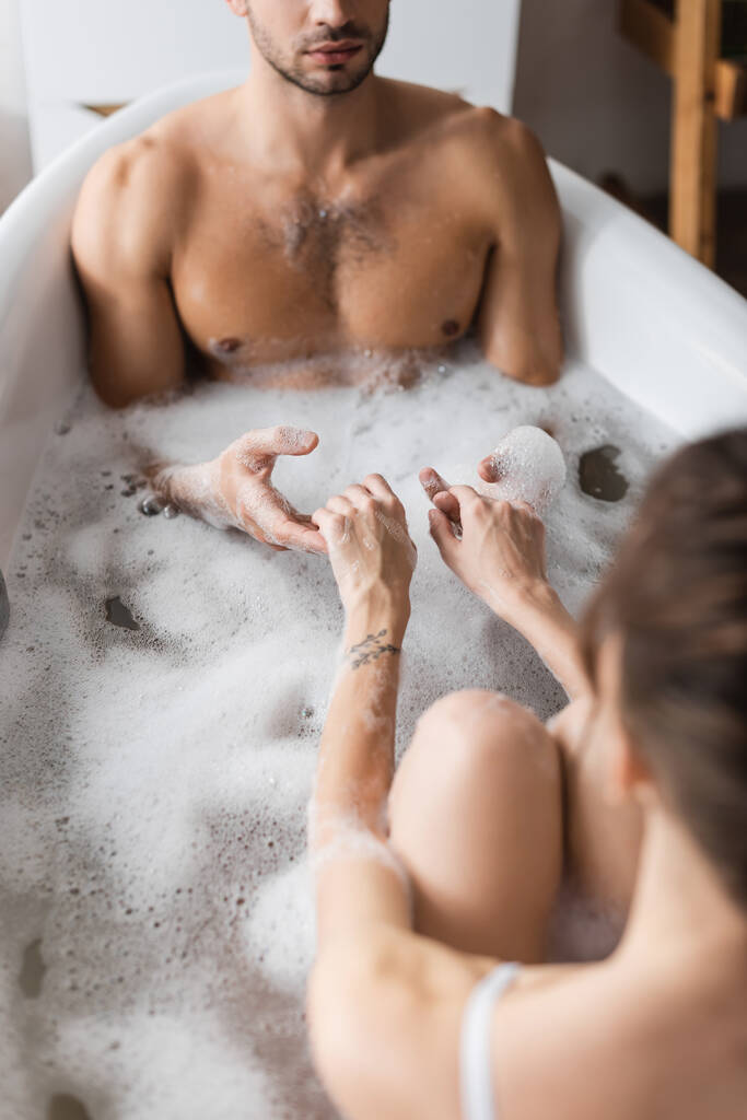 若いカップル手を取りながら入浴泡と自宅  - 写真・画像
