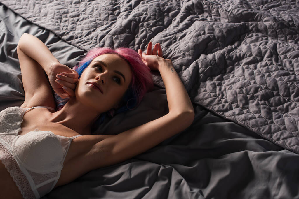 vue grand angle de jeune femme sexy avec tatouage en dentelle sous-vêtements couché sur le lit - Photo, image