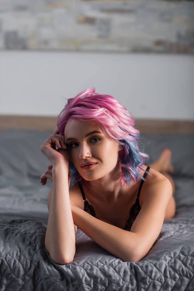 портрет молодої жінки в сексуальній білизні дивиться на камеру і лежить на ліжку
 - Фото, зображення