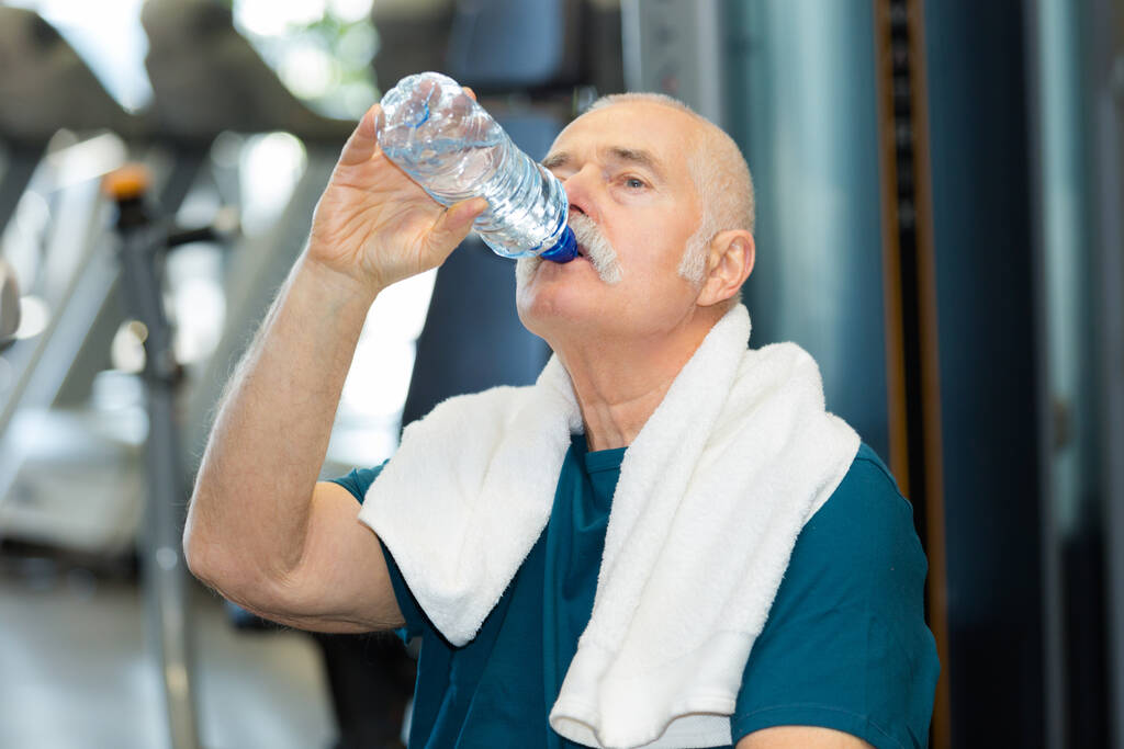 starszy mężczyzna pijący wodę na siłowni - Zdjęcie, obraz
