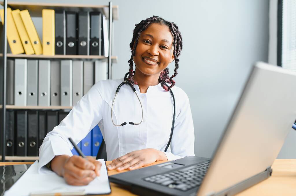 Ritratto di sorridente medico donna che indossa cappotto bianco con stetoscopio in ufficio ospedaliero - Foto, immagini