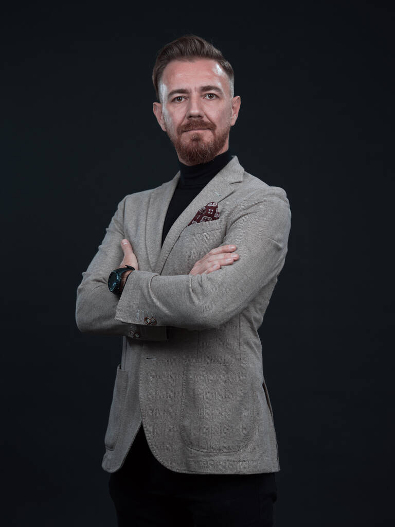 Portrait of a stylish elegant senior businessman with a beard and casual business clothes in photo studio isolated on dark background gesturing with hands - Photo, Image