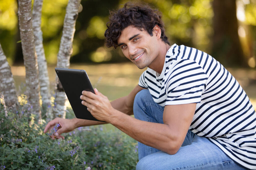 jonge man met tablet in het park - Foto, afbeelding
