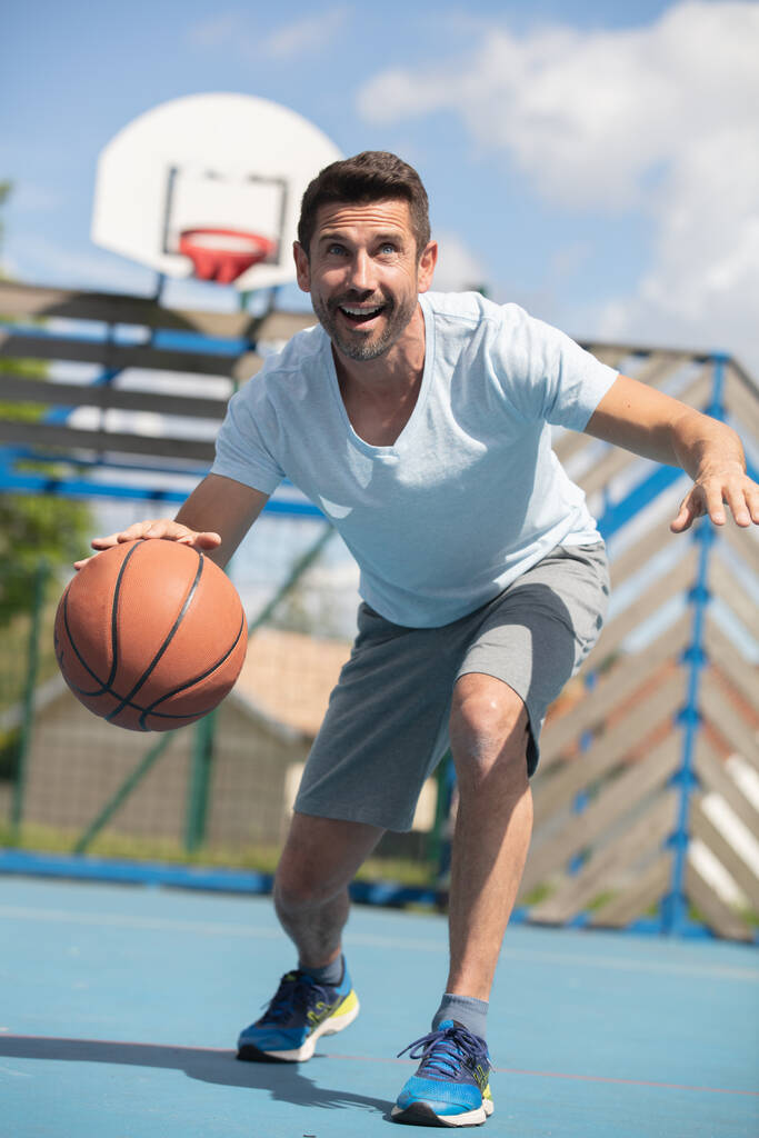 schöner lächelnder Mann mit Basketballkorb - Foto, Bild