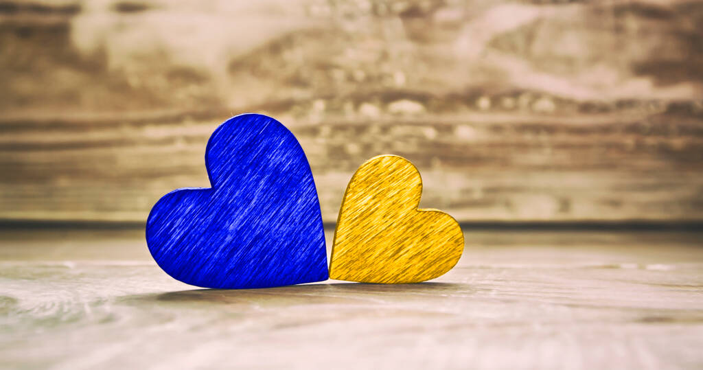 δύο ξύλινες καρδιές σε χρώματα της ουκρανικής σημαίας στο ξύλινο τραπέζι  - Φωτογραφία, εικόνα