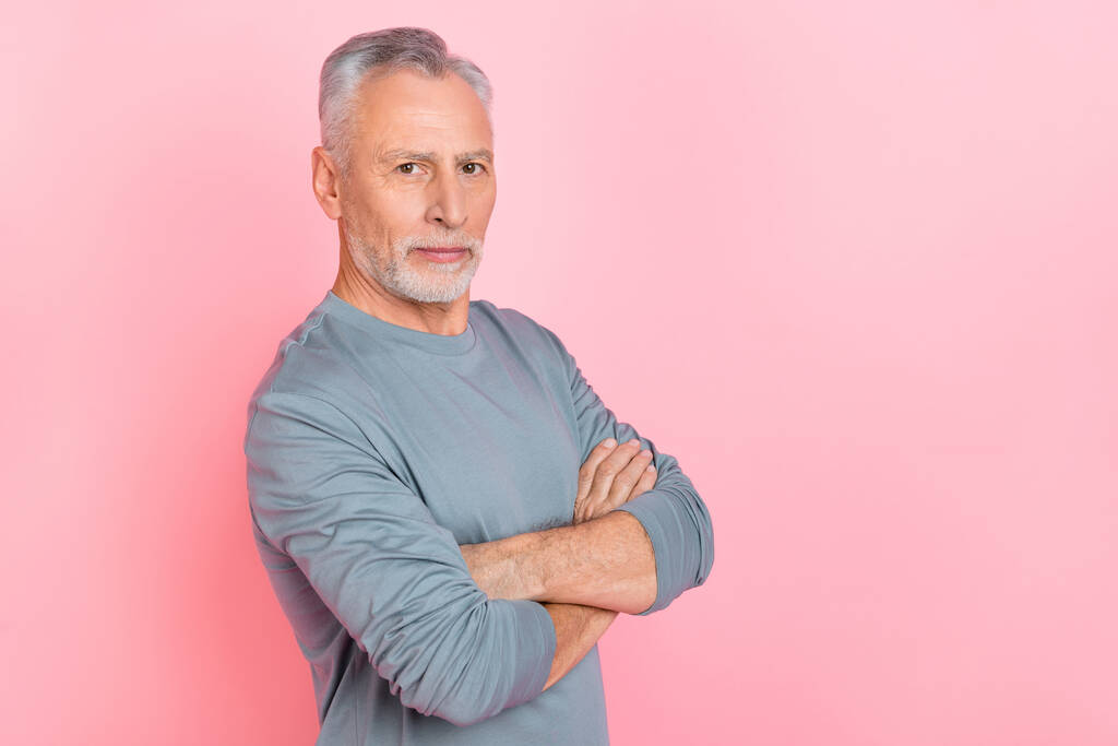 Foto von entzückenden attraktiven Rentner tragen graues Hemd Arme überquert leeren Raum isoliert rosa Farbe Hintergrund - Foto, Bild