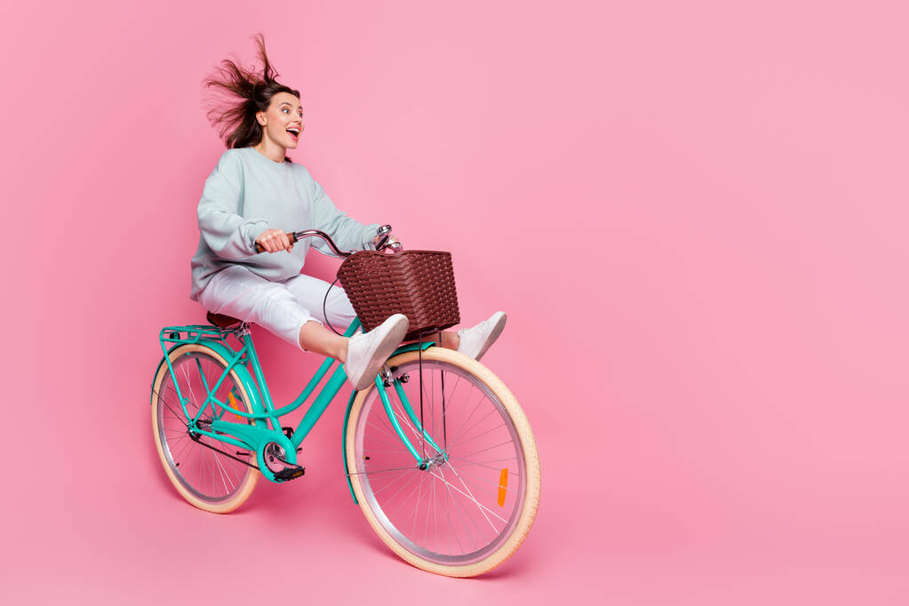 Perfil de tamaño completo foto de peinado bob impresionado millennial lady paseo bicicleta usar sudadera con capucha pantalones zapatos aislados sobre fondo rosa - Foto, imagen