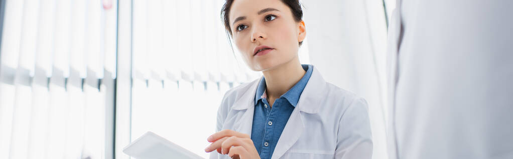 nuori tiedemies valkoisessa takissa, jolla digitaalinen tabletti laboratoriossa, banneri - Valokuva, kuva