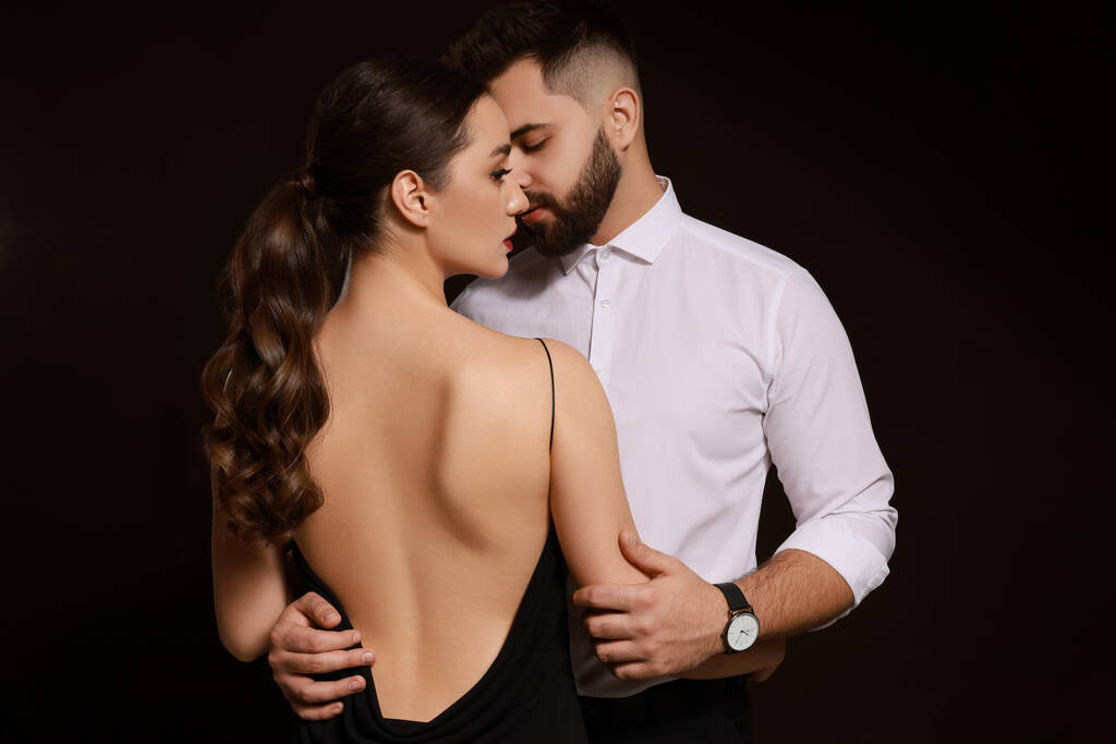 Handsome bearded man with sexy lady on dark background - Photo, Image