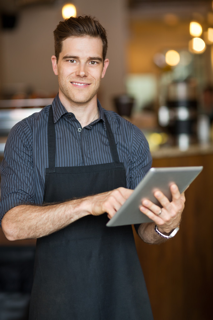 Propietario masculino sosteniendo la tableta digital en la cafetería
 - Foto, Imagen
