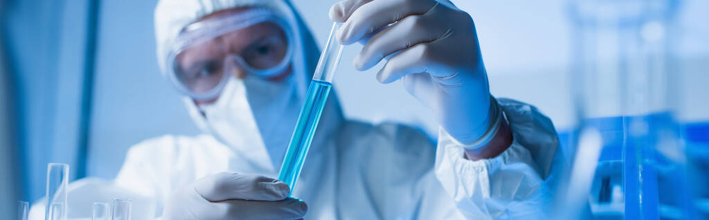 bioinženýr v brýlích a lékařské masce drží zkumavku s tekutinou, banner - Fotografie, Obrázek