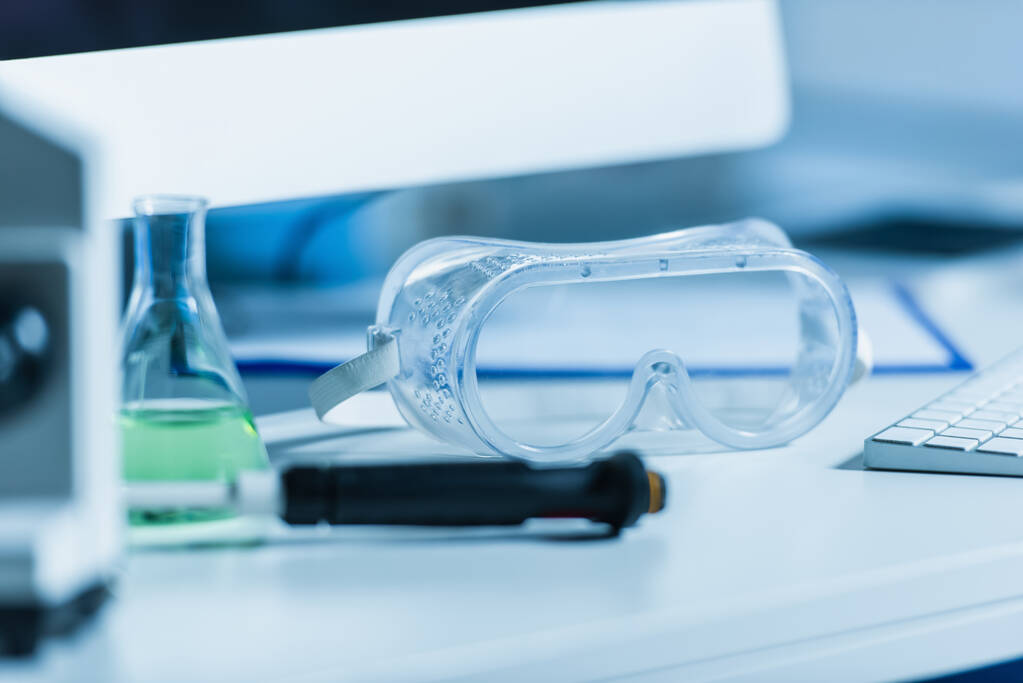 foco seletivo de óculos na mesa em laboratório bio em primeiro plano desfocado - Foto, Imagem