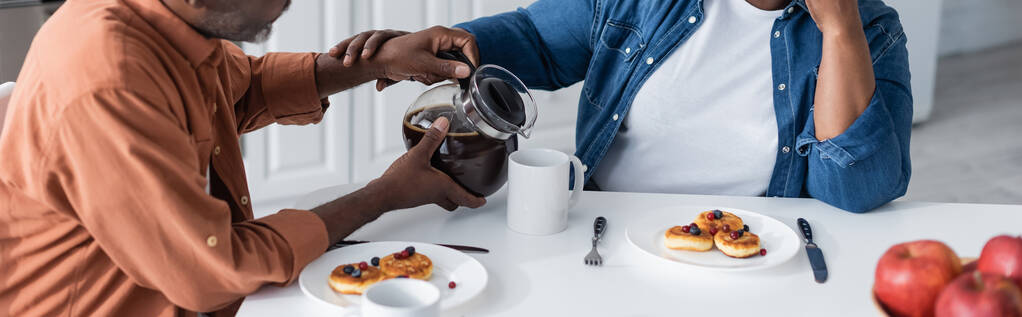 levágott kilátás idős afro-amerikai férfi öntés kávé feleség reggeli közben, banner - Fotó, kép