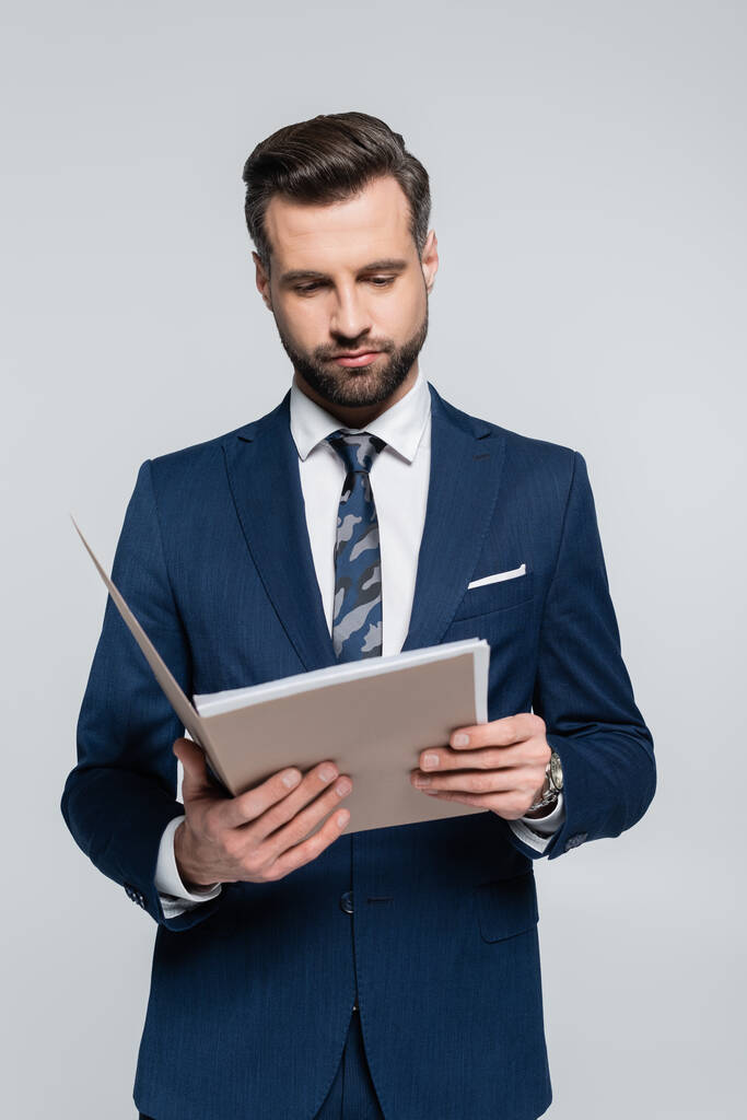 brunetta uomo d'affari in blu blazer lettura documenti in cartella isolato su grigio - Foto, immagini