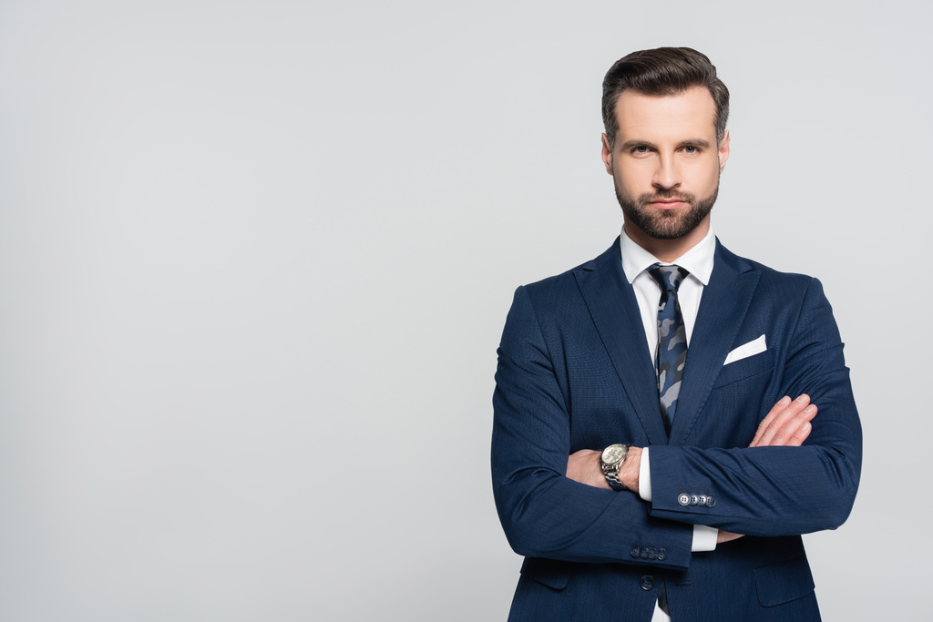 bearded businessman in blue blazer standing with crossed arms isolated on grey - Photo, Image