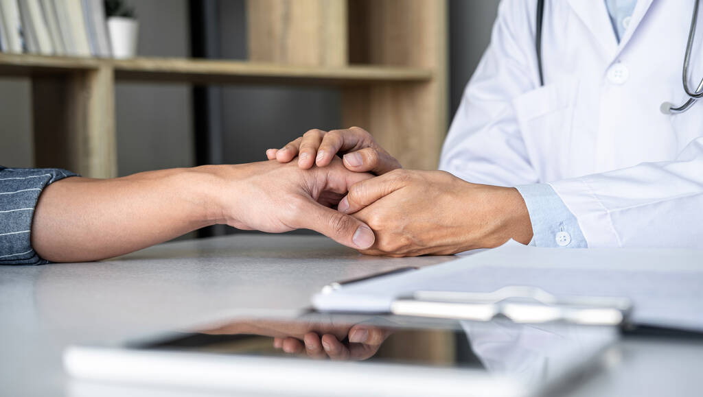 Close-up van arts aanraken patiënt hand voor aanmoediging en empathie op het ziekenhuis, juichen en ondersteunen patiënt, Slecht nieuws, medisch onderzoek, vertrouwen en ethiek. - Foto, afbeelding