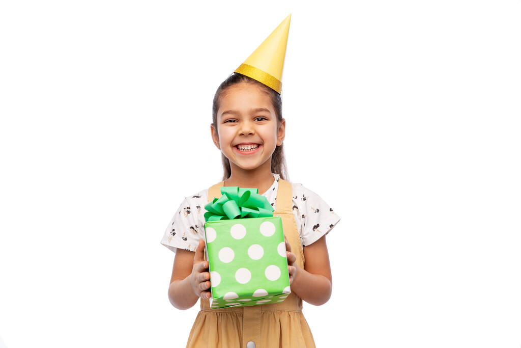 chica sonriente en sombrero de fiesta con regalo de cumpleaños - Foto, imagen