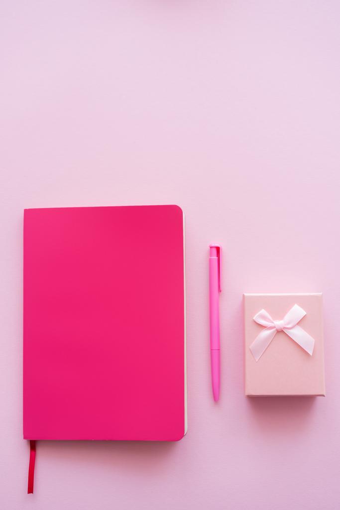 vista superior de la caja de regalo, cuaderno brillante y pluma aislada en rosa - Foto, imagen
