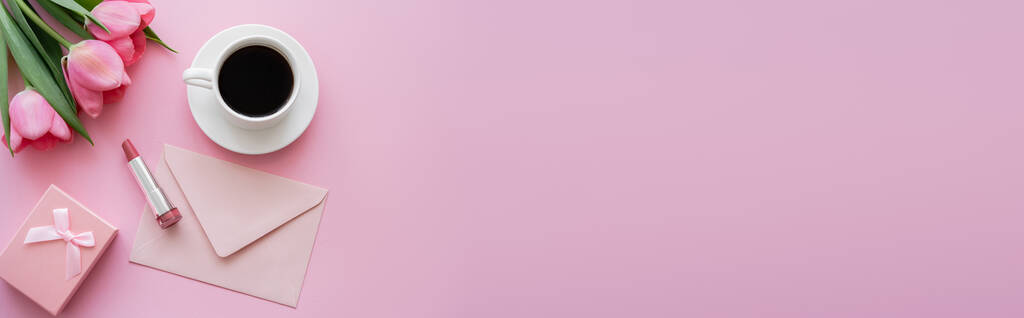 верхний вид цветущих тюльпанов возле помады, конверт и чашку кофе на розовый, баннер - Фото, изображение