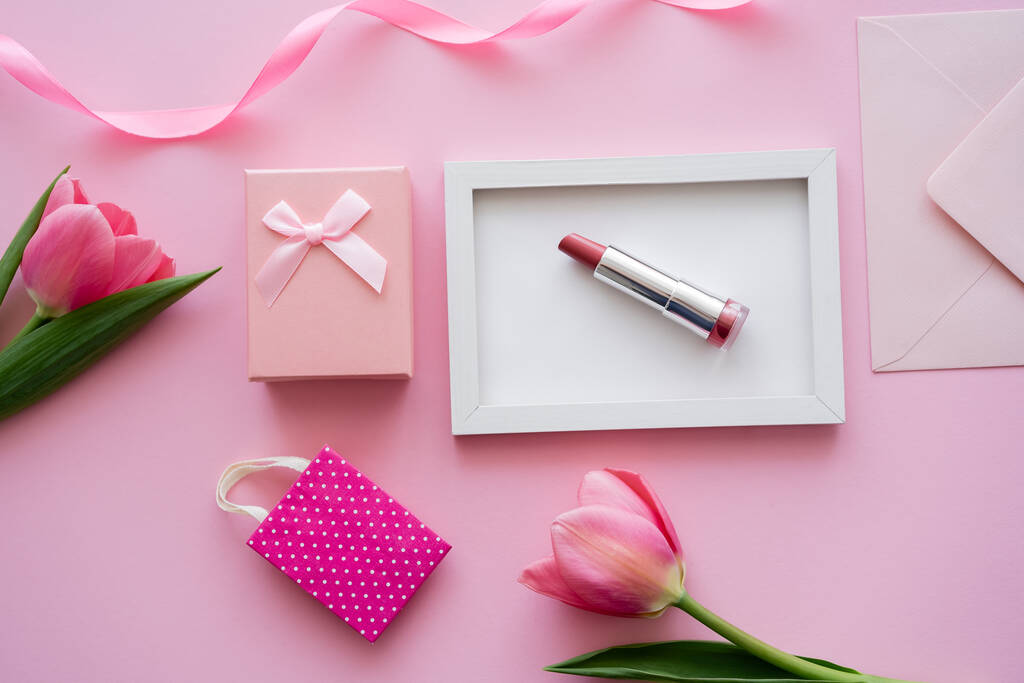 top view tulipánok közelében keret rúzs, boríték és ajándék doboz rózsaszín - Fotó, kép