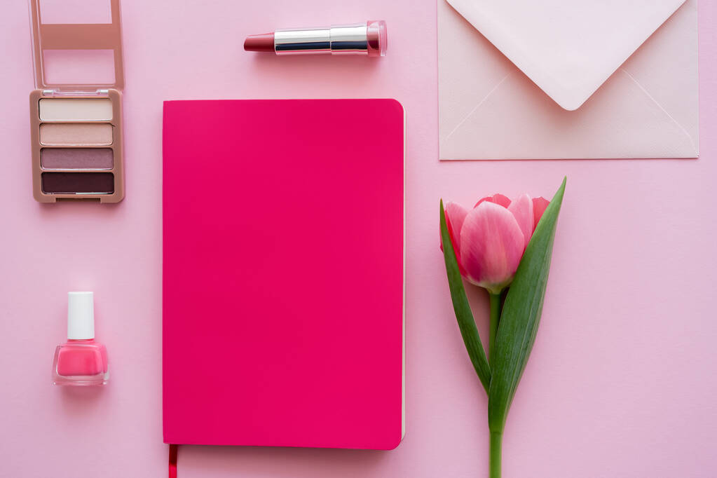 shora pohled na tulipán u notebooku, obálky a dekorativní kosmetiky na růžové - Fotografie, Obrázek