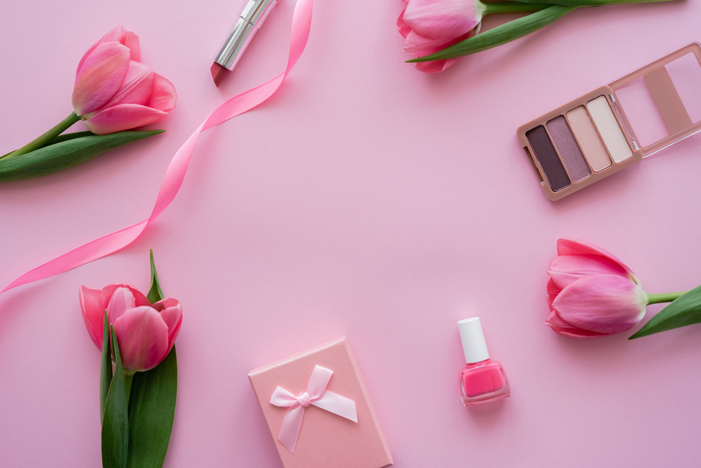 top view ajándék doboz íj közelében dekoratív kozmetikumok és tulipánok rózsaszín - Fotó, kép