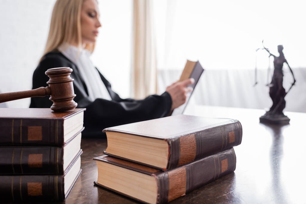 collection of books and gavel near prosecutor reading on blurred background - Foto, immagini