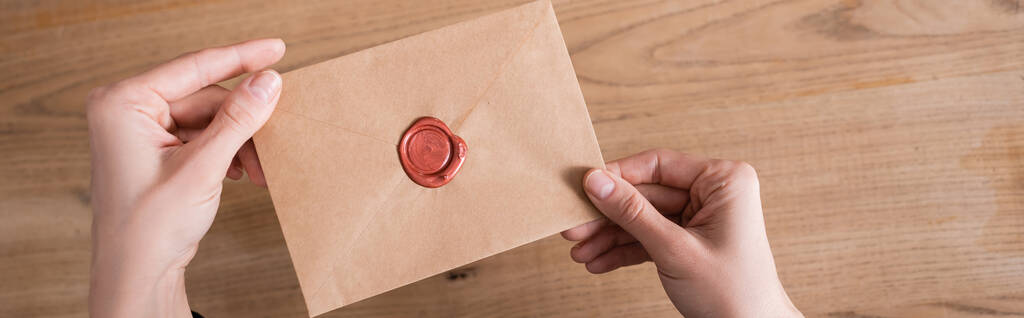 top view of craft paper envelope with wax stamp in hands of cropped notary, banner - Photo, Image