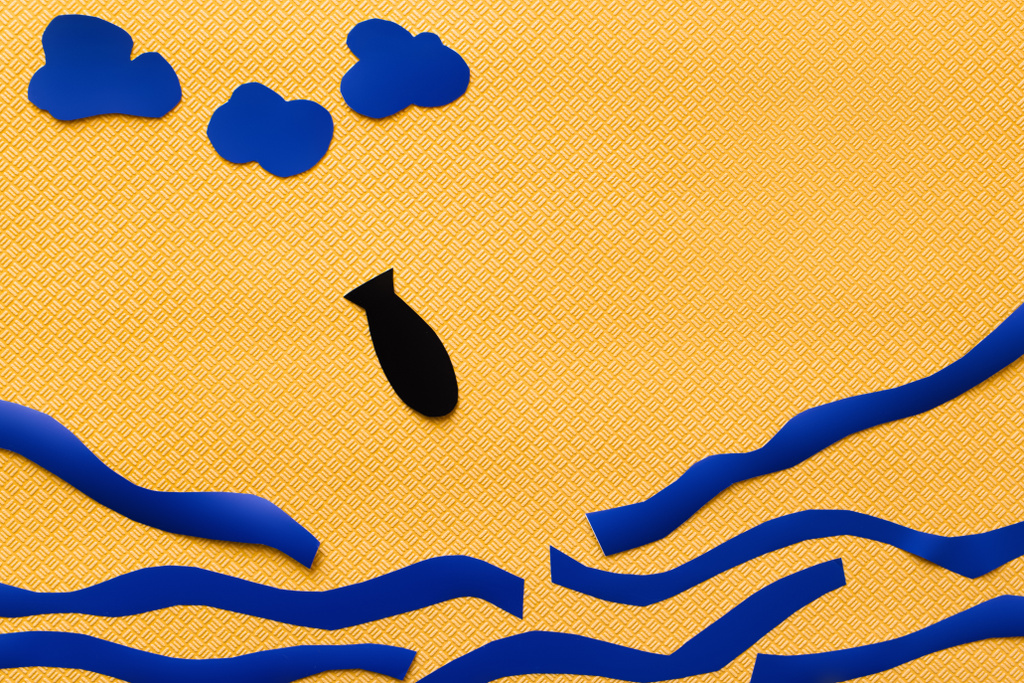 Вид сверху бумажной бомбы возле облаков и картонного моря на текстурированном желтом фоне - Фото, изображение