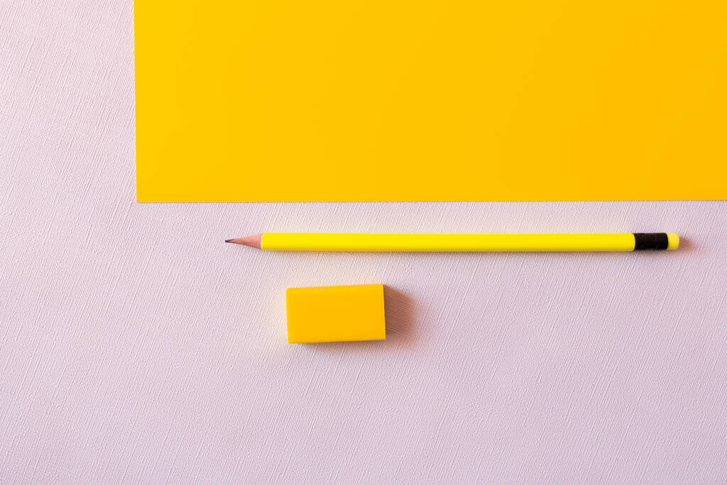 top view of pencil near eraser on white and yellow - Photo, Image