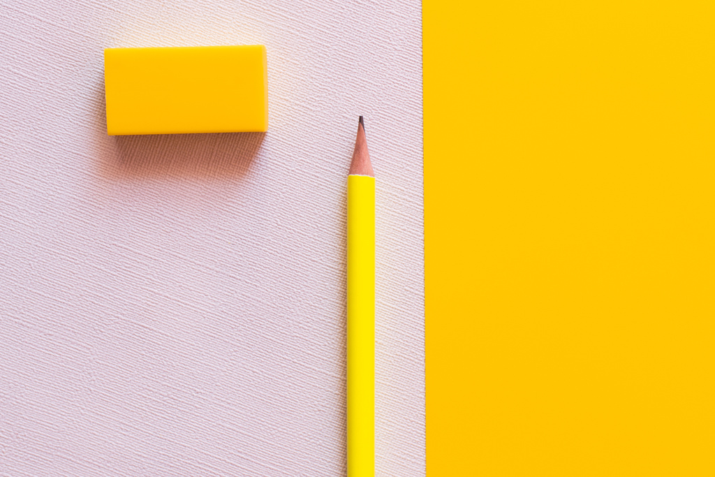 Bleistift und Radiergummi von oben auf weiß und gelb - Foto, Bild