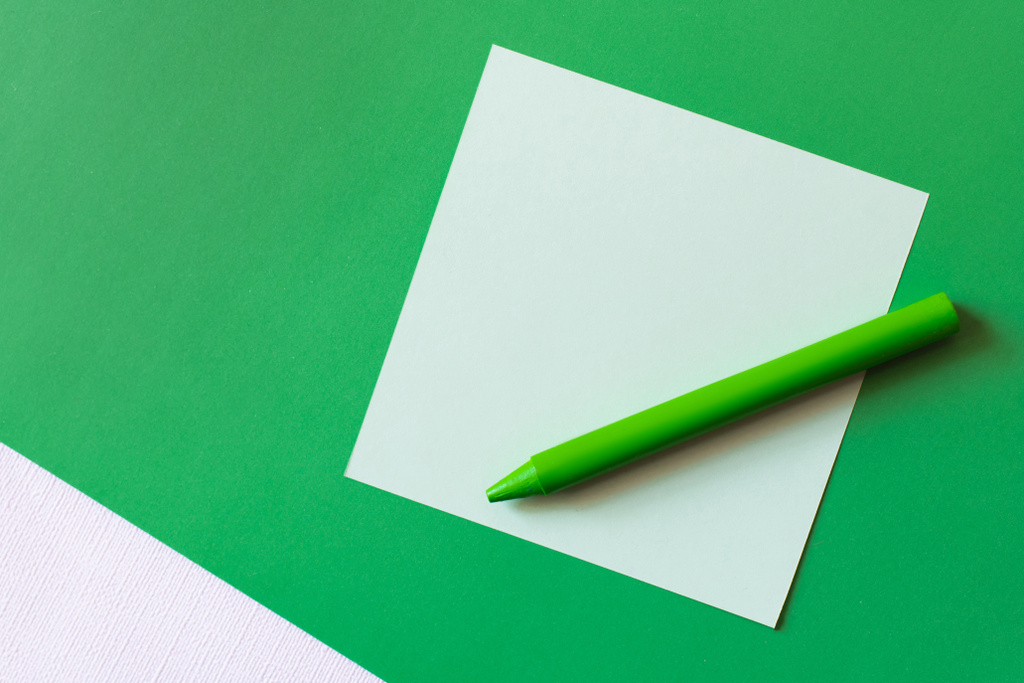 horní pohled pastelky u papírové poznámky na zelené - Fotografie, Obrázek