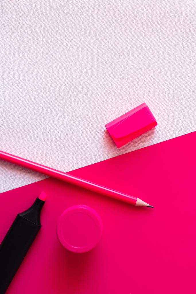 vista superior de la pluma marcador y lápiz cerca del frasco con pintura en blanco y rosa con textura - Foto, imagen
