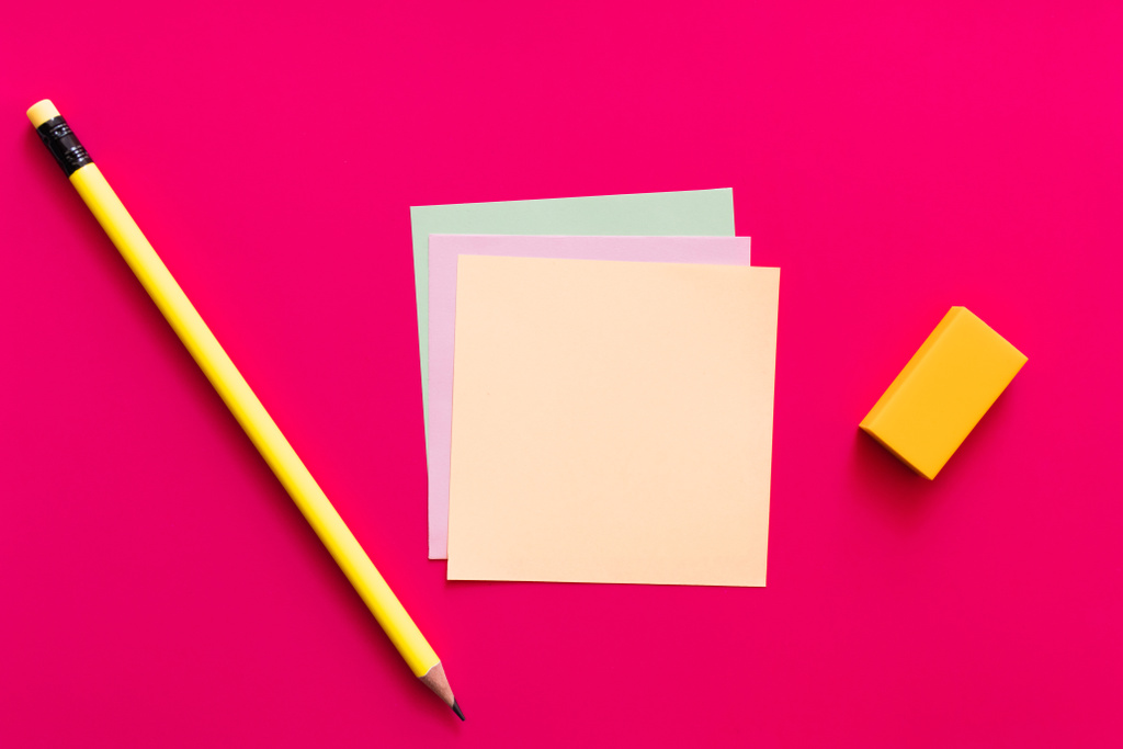 вид зверху на олівець і гумку біля різнокольорових паперових нот на рожевому фоні
  - Фото, зображення