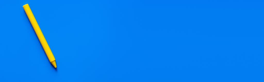 top view of yellow crayon on blue background, banner - Photo, Image