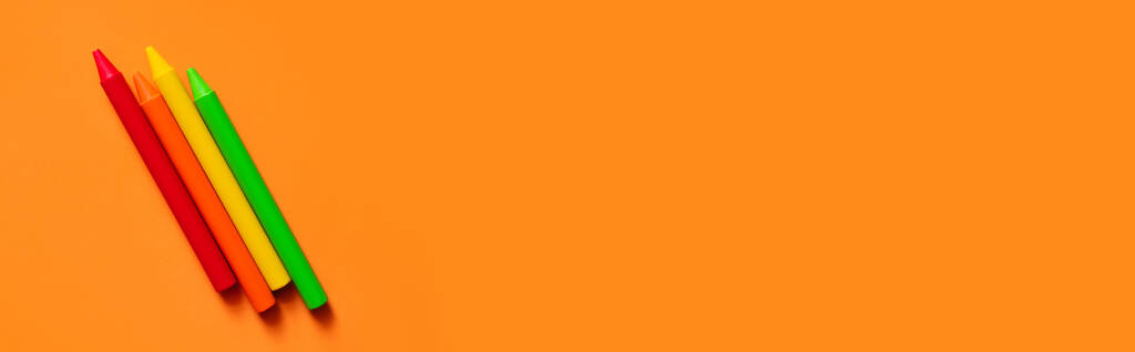 πάνω όψη πολύχρωμες κραγιόνια σε πορτοκαλί φόντο, banner - Φωτογραφία, εικόνα